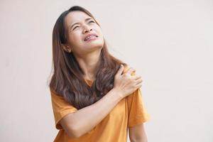 asiatische Frau mit Schulterschmerzen foto
