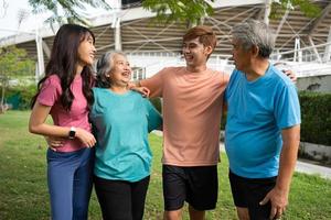 gesund Familie Gruppe Ausbilder trainieren im frisch Luft, und Sie sich ausruhen und Stand zusammen nach Morgen Übungen im Park. draussen Aktivitäten, gesund Lebensstil, stark Körper, passen Zahlen, Gesundheit Pflege. foto