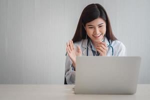 asiatische ärztin besucht online einen patienten in der internetanwendung und hört sich die symptome an und erklärt, wie die anfängliche krankheit behandelt wird, konzept der medizintechnik. foto