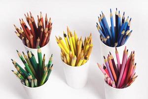 farbig Bleistifte im Weiß Brille auf ein Weiß Hintergrund. oben Aussicht Foto von Stapel von Bleistifte durch Farbe Rot, Gelb, Blau Grün Horizont, Rosa und lila