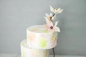 abgestuft bunt Hochzeit Kuchen mit Wafer Papier Blumen mit hell Farben auf ein Stand foto