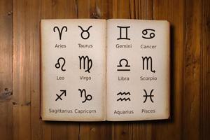 Astrologie Buch gefüllt mit Tierkreis Zeichen auf ein Schreibtisch foto