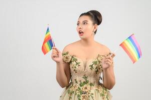 junge asiatische schöne Braut mit Regenbogenfahne auf weißem Hintergrund foto