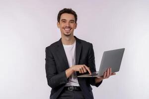 Porträt eines jungen, gutaussehenden, lächelnden Geschäftsmannes, der einen Laptop in den Händen hält, Webseiten auf weißem Hintergrund tippt und durchsucht foto