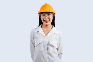 jung weiblich Ingenieur tragen Gelb Helm Stand mit charmant Lächeln Haltung foto