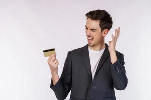 Porträt des unglücklichen Geschäftsmannes, der die Kreditkarte lokalisiert über weißem Hintergrund zeigt foto