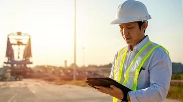 asiatisch Ingenieur mit Helm mit Tablette pc Computer inspizieren und Arbeiten beim Konstruktion Seite? ˅ foto