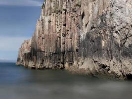 Felsen mit geraden Kanten bei Ebbe eines Strandes an der asturischen Küste foto