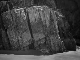 Felsen mit geraden Kanten bei Ebbe eines Strandes an der asturischen Küste foto