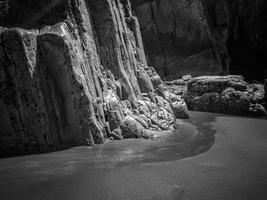 Felsen mit geraden Kanten bei Ebbe eines Strandes an der asturischen Küste foto