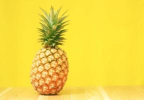 reife Ananas auf gelbem hölzernem Hintergrund foto