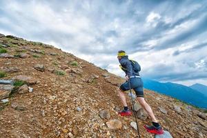 Skyrunner Athlet beim Training in den Bergen mit Stöcken foto