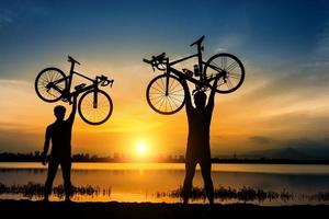 Silhouette von zwei männlichen Radfahrern bei Sonnenuntergang foto