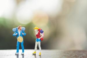 Miniaturmenschen mit stehenden und gehenden Rucksäcken, Reise- und Abenteuerkonzept foto