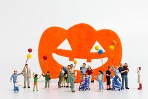Miniaturleute, die Ballons lokalisiert auf einem weißen Hintergrund halten, Halloween-Konzept
