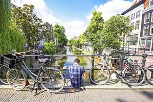 Ein Mann, der auf einer Brücke in Utrecht, Niederlande, sitzt foto