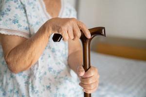 asiatisch Alten Behinderung Frau halten wackeln Stock, Holz Stock, runden handhaben, Gehen Hilfe zum Hilfe zu gehen. foto