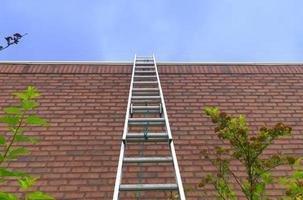 Leiter rot Backstein Mauer Freiheit Konzept Aspirationen Tore Motivation Erfolg Geschäft Gelegenheit Blau Himmel foto