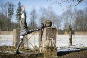 Eine junge sportliche Frau führt Yoga und Meditationsübungen im Freien durch foto