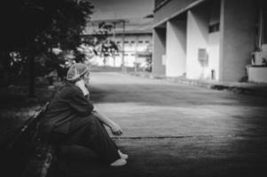 müde depressive asiatische krankenschwester trägt gesichtsmaske blaue uniform sitzt auf dem krankenhausboden, junge ärztin gestresst von harter arbeit foto