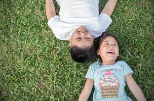 Lächeln Kinder Lüge Nieder auf Gras foto