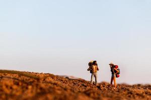 Miniaturreisende mit Rucksäcken Bergsteigen, Wandern und Rucksackwandern im Freien Konzept foto