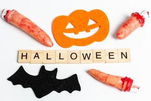 Halloween-Party Requisiten mit Holzklötzen mit dem Text Halloween auf einem weißen Hintergrund foto