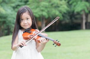 süß asiatisch Mädchen abspielen Violine foto