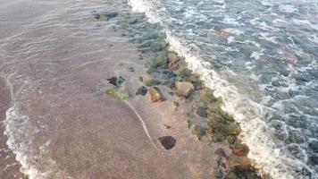 kleine Meereswellen stürzen von kleinen Kieselsteinen an die Küste. Ruhe vor der Bewegung des Meerwassers oder der Wellen. foto