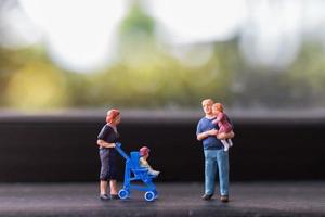 Miniatureltern mit Kindern, die draußen gehen, glückliches Familienkonzept foto