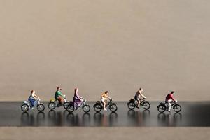 Miniaturreisende, die Fahrrad fahren, gesundes Lebensstilkonzept foto