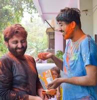 Delhi, Indien - - Februar 26 2023 - - indisch Familie Menschen spielen Farben auf holi Festival, halten anders Farben, holi Festival Feierlichkeiten im Delhi, Indien foto