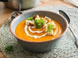 Kürbis Suppe im ein Schüssel serviert mit Petersilie und Croutons. vegan Suppe. das Erntedankfest Tag Lebensmittel. Halloween Mahlzeit. foto