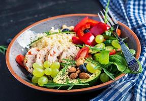 Buddha Schüssel Gericht mit Hackbraten, Bulgur, Avocado, Süss Pfeffer, Tomate, Gurke, Beeren und Nüsse. Entgiftung und gesund Superfoods Schüssel Konzept. foto