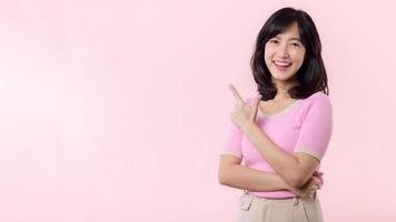 Porträt jung schön asiatisch Frau glücklich Lächeln zeigen Finger und Hand zu zeigen auf Kopieren Raum isoliert auf Rosa Hintergrund. attraktiv weiblich Person Geste Beachtung zu diese Förderung. foto
