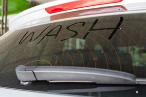 schmutzig Rückseite Fenster von das Auto und Inschrift waschen. waschen Text auf schmutzig Wagen. foto