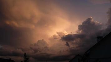 Fragment von ein Haus gegen das Hintergrund von ein Sonnenuntergang oder Sonnenaufgang, ein lila Himmel mit Wolken. Dämmerung bunt Himmel. Luft und flauschige Wolken wie ein Konzept von Hoffnung. dramatisch Himmel. foto