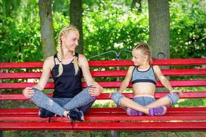 Mutter mit Tochter Sitzung auf Bank foto