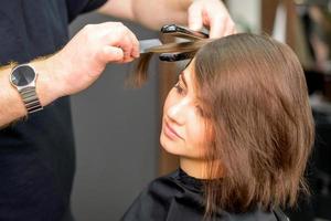 Friseur ist begradigen das Haar foto