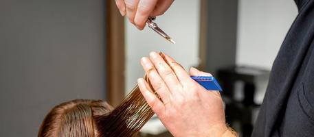 Friseur Hände schneidet weiblich Haar foto