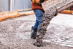 Nahansicht Schuss von Beton Gießen auf Verstärkung Metall Riegel von Fußboden im industriell Konstruktion Seite? ˅ foto