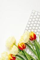 eben Lügen Valentinstag Tag Hintergrund mit Computer Tastatur und Tulpe Strauß. oben Sicht. Weiß Raum zum Kopieren foto