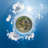 winziger Planet im Himmel mit Wolken, die die Altstadt, die Stadtentwicklung, historische Gebäude und Kreuzungen überblicken. Umwandlung eines sphärischen 360°-Panoramas in eine abstrakte Luftaufnahme. foto