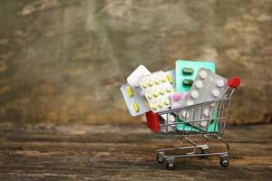 Einkaufen Wagen mit Tabletten auf alt Holz Hintergrund. foto