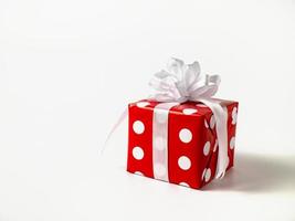 Überraschung Geschenk zum Neu Jahr, Weihnachten, Geburtstag, geliebte. rot Polka Punkt Box mit groß Bogen auf Weiß Hintergrund. foto