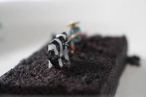 Miniatur Zahl von ein Farmer wie wenn er war Pflügen ein Schokolade Schwamm Kuchen. foto