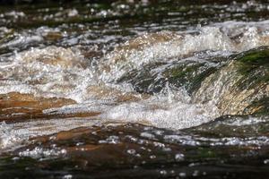 Wasser auf ein Fluss stürzen mit Schaum und Blasen. foto