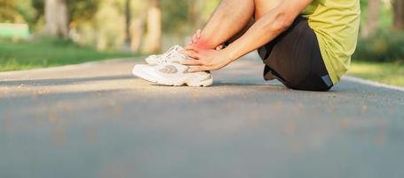 jung Erwachsene männlich mit seine Muskel Schmerzen während Betrieb. Läufer Mann haben Bein schmerzen fällig zu Knöchel Verstauchungen oder Achilles Sehnenentzündung. Sport Verletzungen und medizinisch Konzept foto