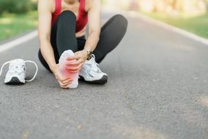 jung Erwachsene weiblich mit seine Muskel Schmerzen während Betrieb. Läufer Frau haben Bein schmerzen fällig zu plantar Fasziitis. Sport Verletzungen und medizinisch Konzept foto