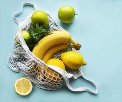 saftig reife Zitrusfrüchte und Bananen in einer umweltfreundlichen Einkaufstasche foto